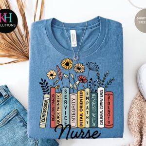 Floral nurse shirt with stacked colorful books and inspirational nursing words on athletic heather gray t-shirt. Image Description